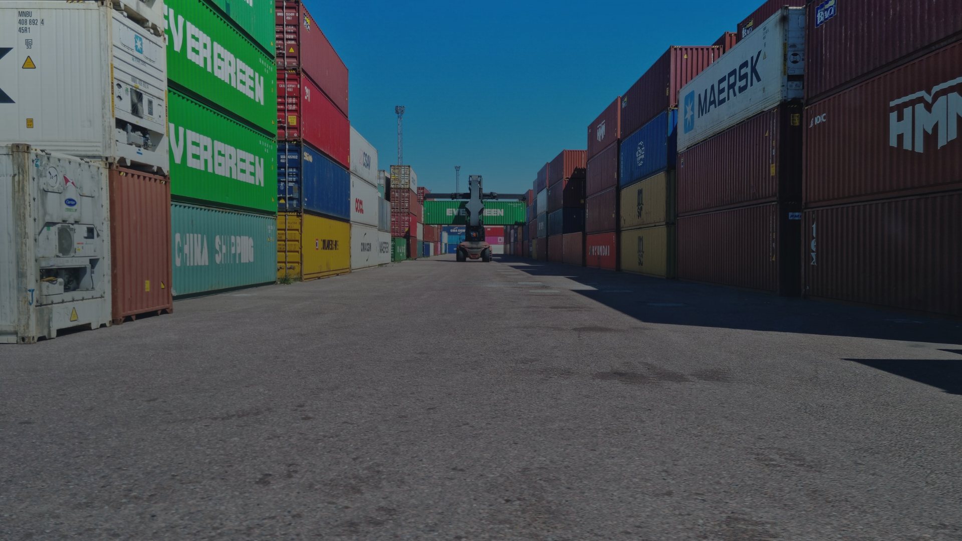 Allée de conteneurs maritimes empilés dans un dépôt portuaire